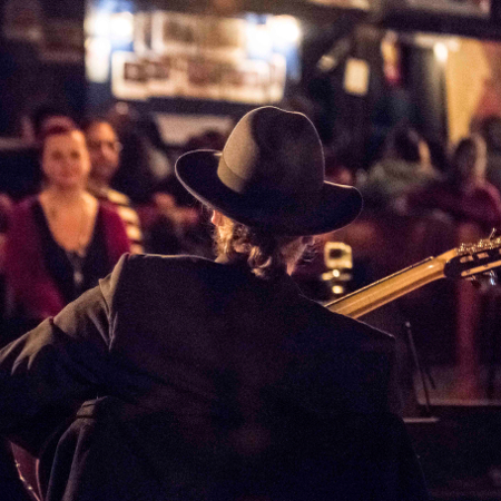 Marc Wencelius performing to an audience, viewed from behind