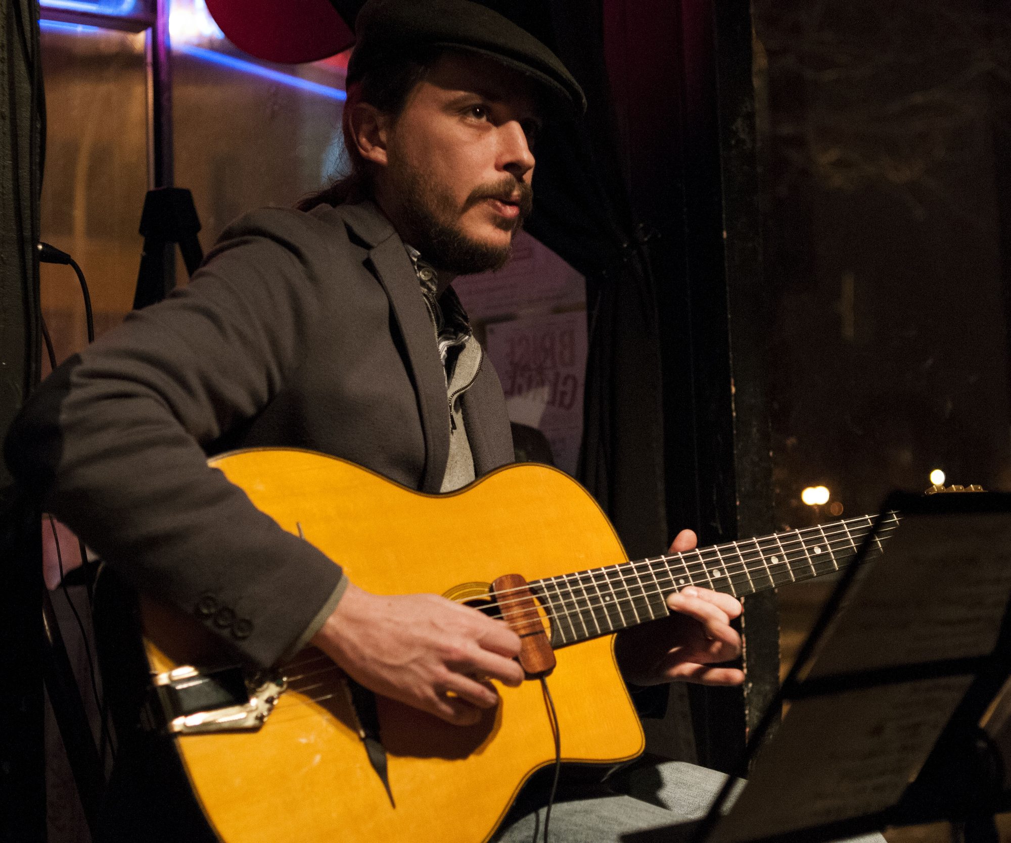 Marc Wencelius playing his acoustic guitar on stage