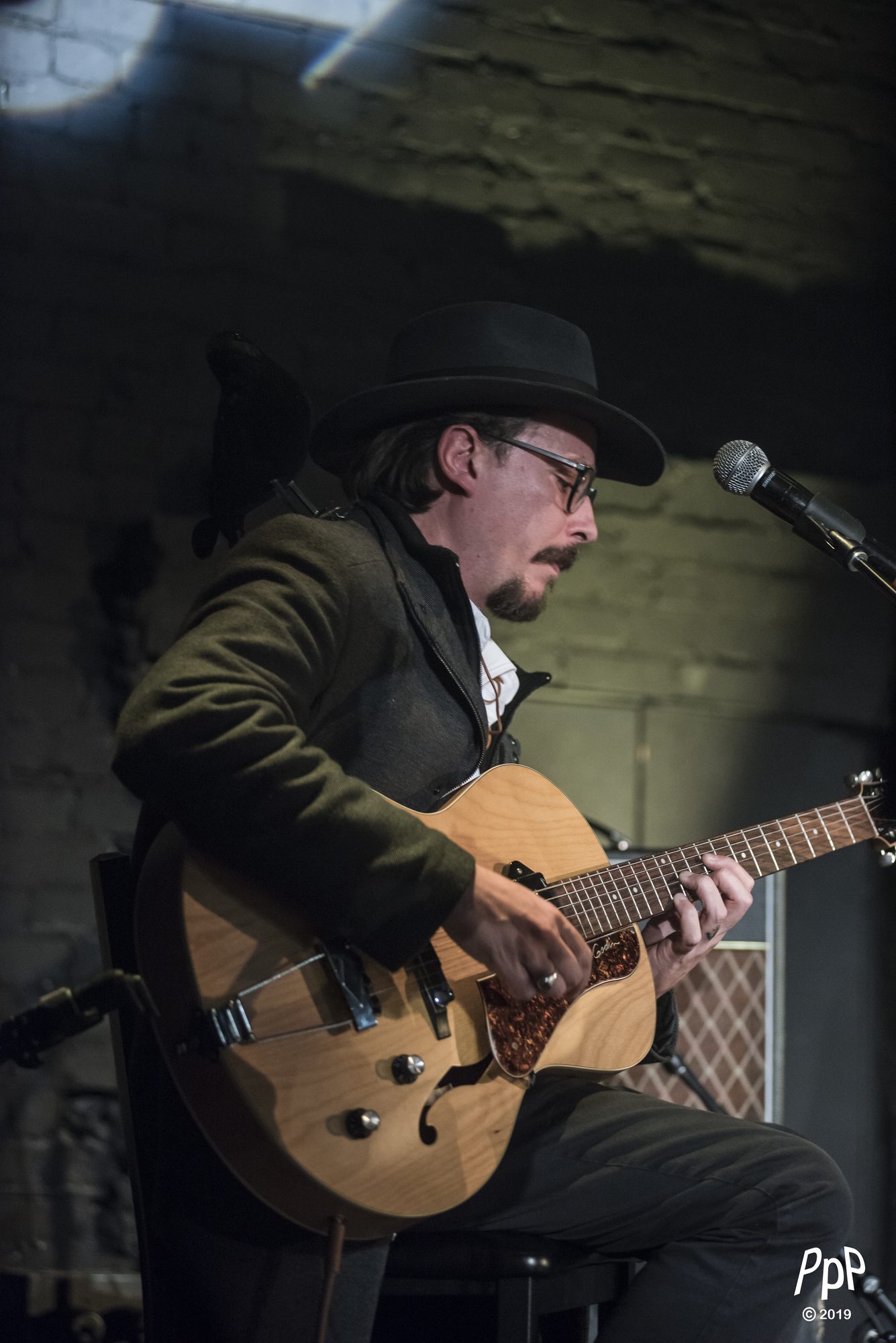 Marc Wencelius playing archtop guitar beside a microphone, 2019
