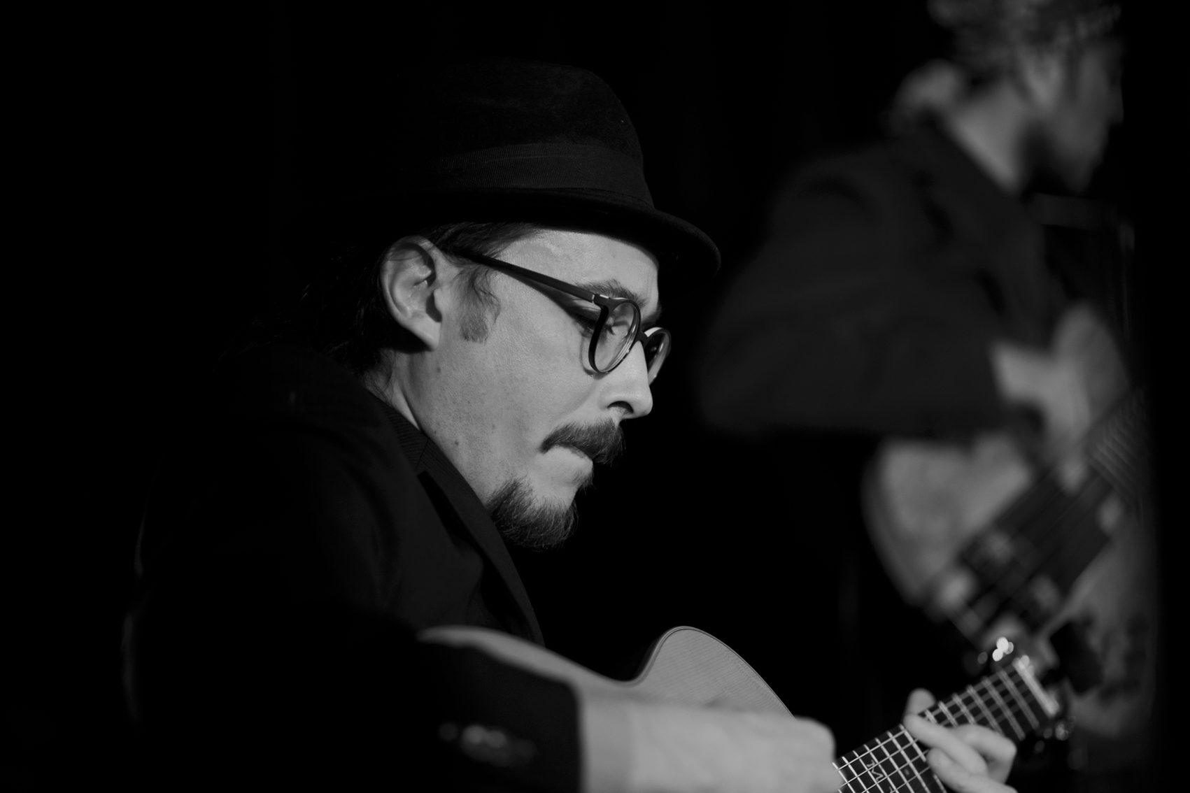 Black-and-white profile of Marc Wencelius playing guitar