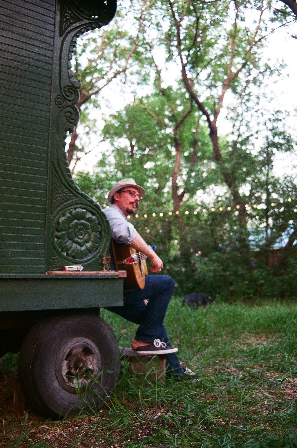 Marc Wencelius outdoors by a green caravan, shot on film