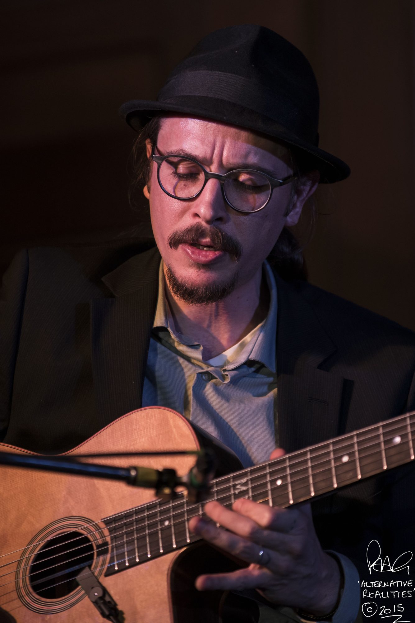 Close-up of Marc Wencelius playing acoustic guitar, 2015
